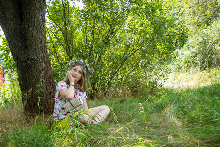 girl in a wreath under a treeの写真素材