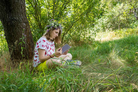 girl in a wreath under a treeの写真素材