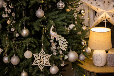 New Year's silver decorations on the tree - layers, tambourines, peacock, decorations hanging on the tree and a lampの写真素材