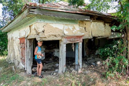 a boy at an abandoned, collapsed old house in the villageの写真素材