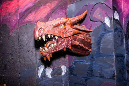 toy dragon head with spikes and teeth on the wall in the children's recreation centerの写真素材