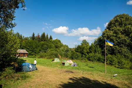 camping in the mountains with tents, log house, tourismの写真素材