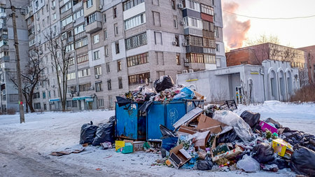 garbage cans in winter, old containers, blue trash cans, garbage bags, cardboard boxes, thrown, on the street, yard, snow, cold, city cleaning, eco, ecology, street, remains of boxの写真素材