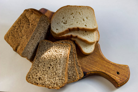 slices of bread of different types, stacked on a wooden board, white, rye, part of the dark, fresh,...