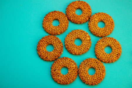 homemade cereal cookies, crushed nuts, classic round shape, hole in the middle, bright blue-turquoise surface, contrast with elements, appetizing composition, bakingの写真素材