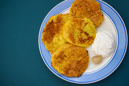 fried potato pancakes with sour cream and pickled garlic, golden crust, traditional Ukrainian dish
