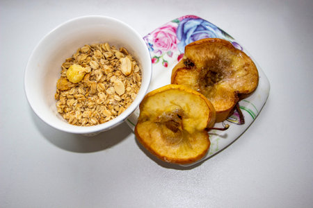 baked apples on plate and dry oatmeal with nuts, corn balls, cereal mix, vitamins, breakfast,...