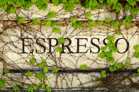 Outdoor Espresso sign on stone wall covered with ivyの写真素材