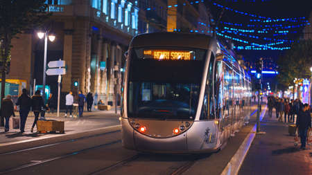 Nice, France - November 2, 2018 - Tram at night on Massena square with crowds of people on the streetのeditorial素材