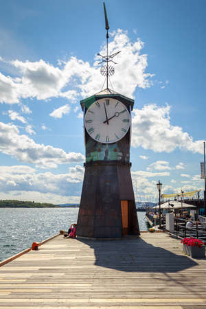 Oslo, Norway - 01 AUG 2014: Clock of the City port with yachts, ships and boatsのeditorial素材