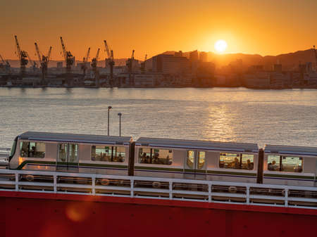 Red Kobe port monorail bridge at sunset twilight in Japan