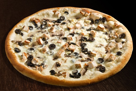 Special pizza with extra cheese, chicken breast, olives and mushrooms - isolatedの写真素材