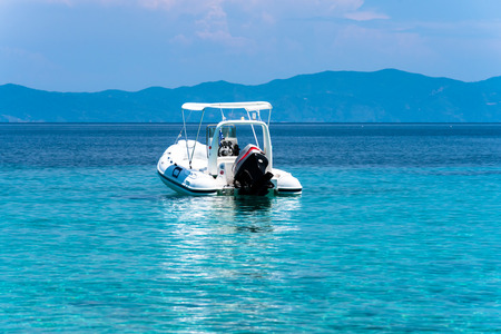 Stationary speed boats on  a calm sea, Mount Athos in the backgroundの写真素材