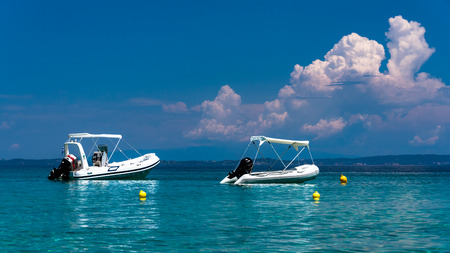 Stationary speed boats on  a calm sea, Mount Athos in the backgroundの写真素材