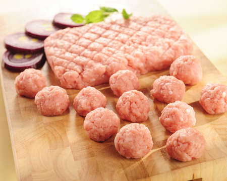 raw minced meat of ham on a cutting board and vegetables.の写真素材