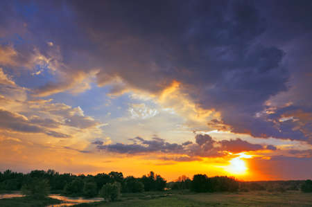 Beautiful sunrise and dramatic clouds on the sky  Flood waters of Narew river, Poland の写真素材
