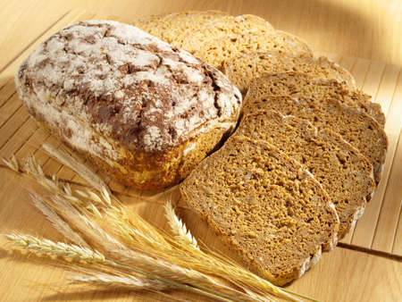 Freshly baked bread and wheat on table