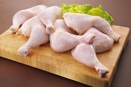Fresh raw chicken legs arrangement on kitchen cutting boardの写真素材