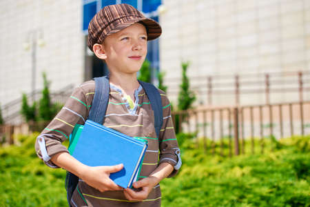 Young pensive kid in front of school buildingの写真素材