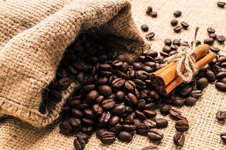 Bag of coffee beans with cinnamon and anise on sackclothの写真素材