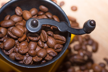 Coffee grinder with coffee beans on wooden table background.の写真素材
