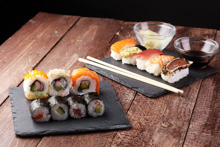 close up of sashimi sushi set with chopsticks and soy - sushi roll with salmon and sushi roll with smoked eel, selective focus.の写真素材