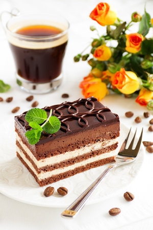 Chocolate cake with coffee and orange roses on a light background.の写真素材
