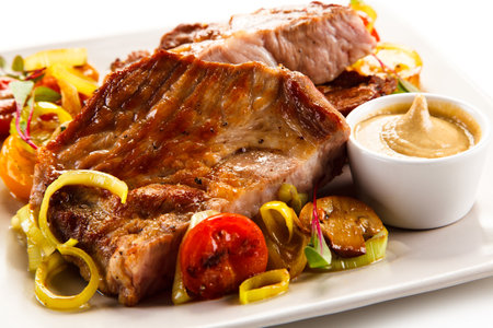 Grilled Pork Ribs with Vegetables and Sauce on White Backgroundの写真素材