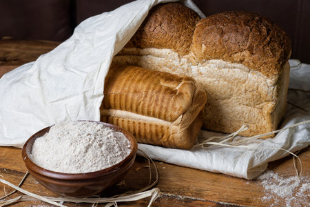 different bread on the wooden table, flour, sackcloth, bowlの写真素材