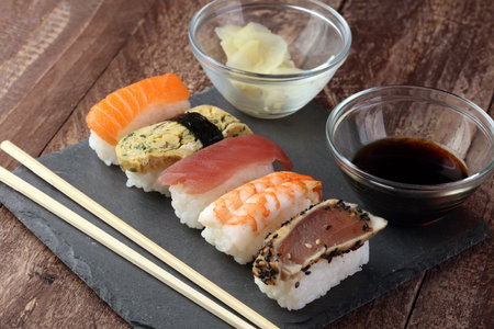 Sushi set with chopsticks and soy sauce on a wooden tableの写真素材