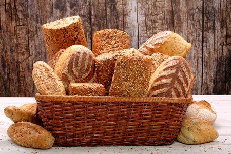 Healthy grainy bread in wicker basket on wooden backgroundの写真素材