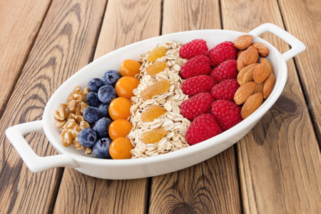 bowl of oat flakes with berries on wooden table, closeupの写真素材