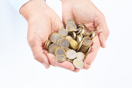 Coins in the hands of a businessman on a white background.の写真素材