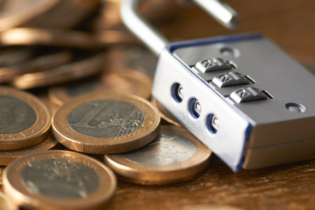 Close up of a padlock on a pile of euro coins.の写真素材