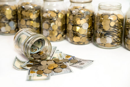 Saving money in the glass jar with coins on white background.の写真素材