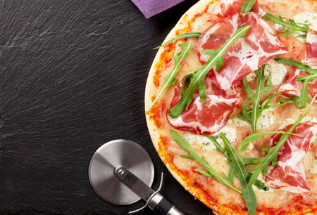 Pizza with prosciutto and mozzarella on stone table. Top view with copy spaceの写真素材