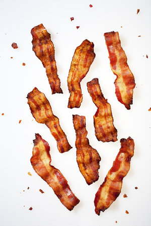 Crispy fried bacon strips on white background. Top view.の写真素材