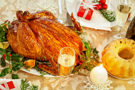 roasted turkey on a festive table with a glass of white wineの写真素材