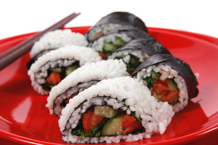 Japanese sushi rolls on red plate, close-up, isolated on whiteの写真素材