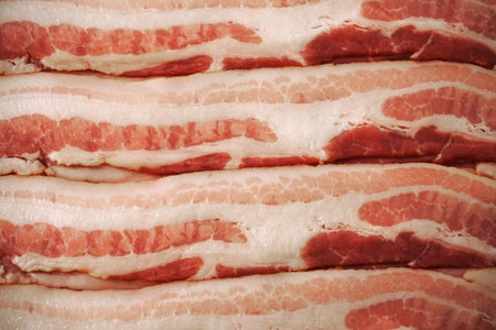Slices of bacon as a background. Selective focus. Toned.