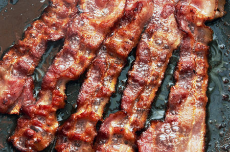 Bacon slice being cooked in frying pan. Close up.の写真素材