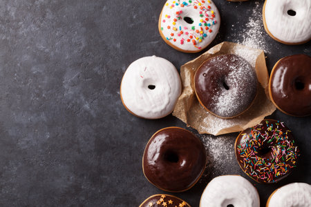 Colorful donuts on stone table. Top view with copy spaceの写真素材