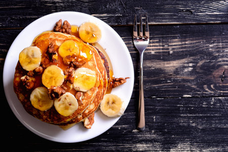 Pancakes with banana  , walnut & honey on wood background .の写真素材