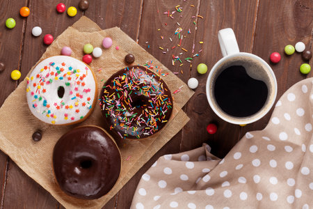 Donuts and coffee on wooden table. Top viewの写真素材