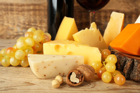 Red wine and stump with variety of cheese on wooden backgroundの写真素材