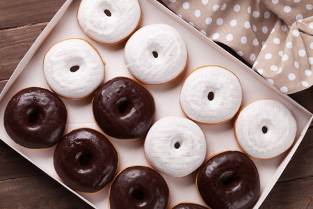 Donuts in box on wooden table. Top viewの写真素材