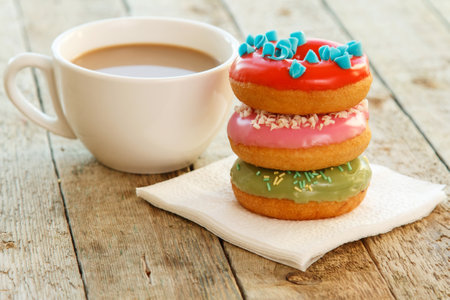 Cup of coffe and colorful donuts on the tableの写真素材