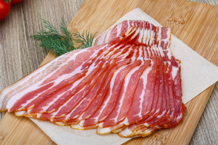Fresh cold sliced bacon with dill branch on the wood backgroundの写真素材