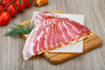 Fresh cold sliced bacon with dill branch on the wood backgroundの写真素材