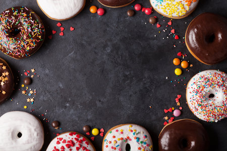 Colorful donuts on stone table. Top view with copy spaceの写真素材